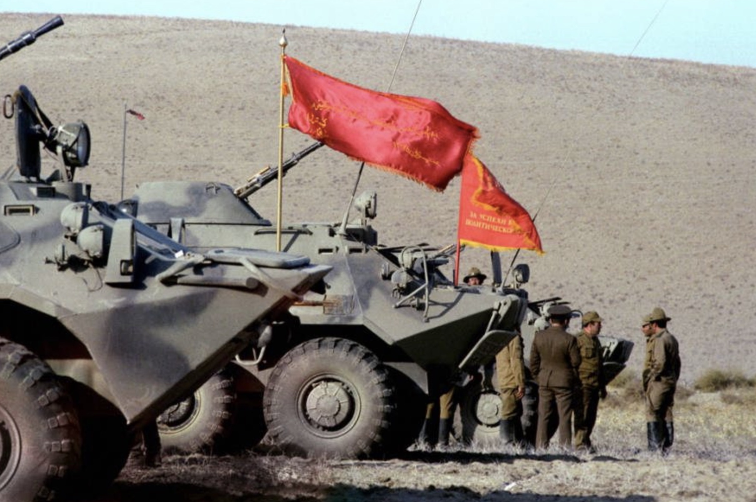 Soviet soldiers stand by armored vehicles. 